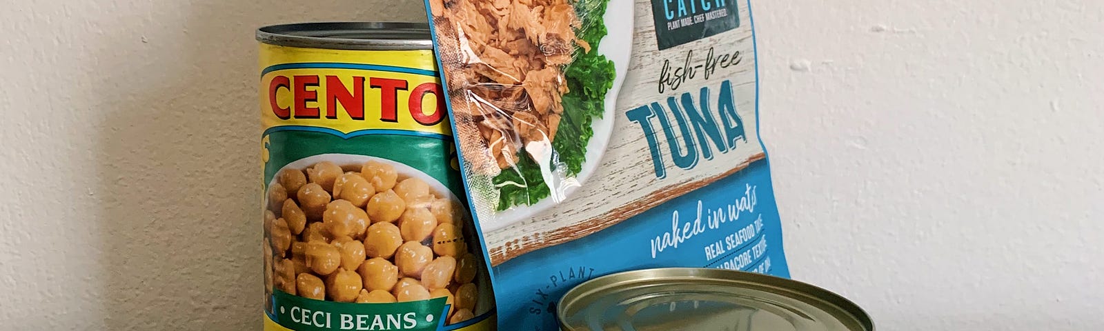 One can of Cento chickpeas and two types of store-bought vegan tuna substitutes, one in a pouch, one in a short can.