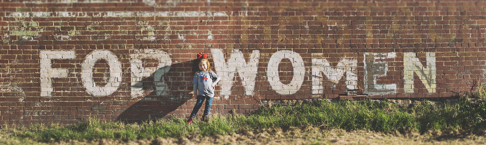 Grafitti of the words ‘for women’ on a brick wall