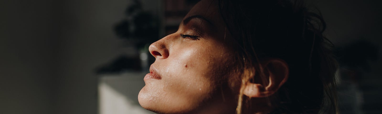 A young woman closes her eyes and breathes in, coping with loneliness and isolation.