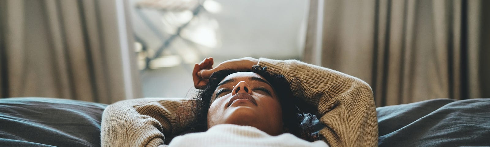 Black woman lying down with eyes closed.