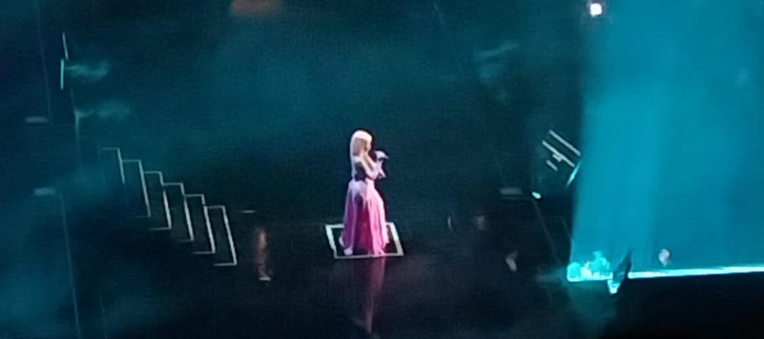 Nicki Minaj alone on stage, looking like a Disney Princess in a pink poofy dress