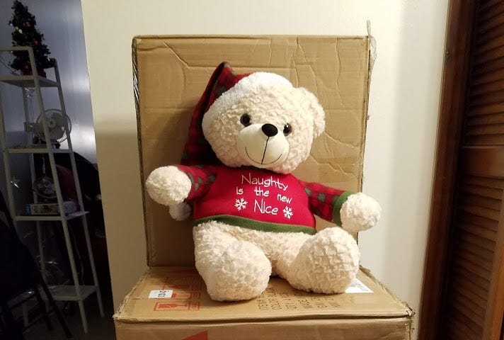 Large stuffed bear on a chair shaped box