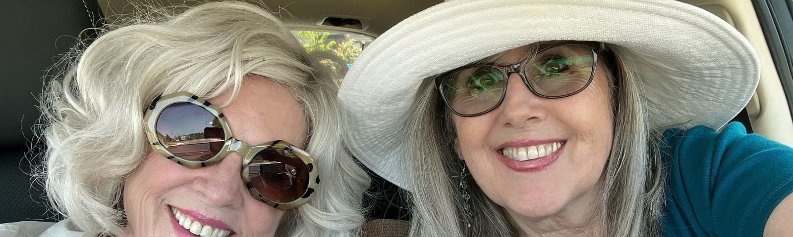 An adult woman (the author) and her mother wearing sunglasses in the car getting ready to take a drive.