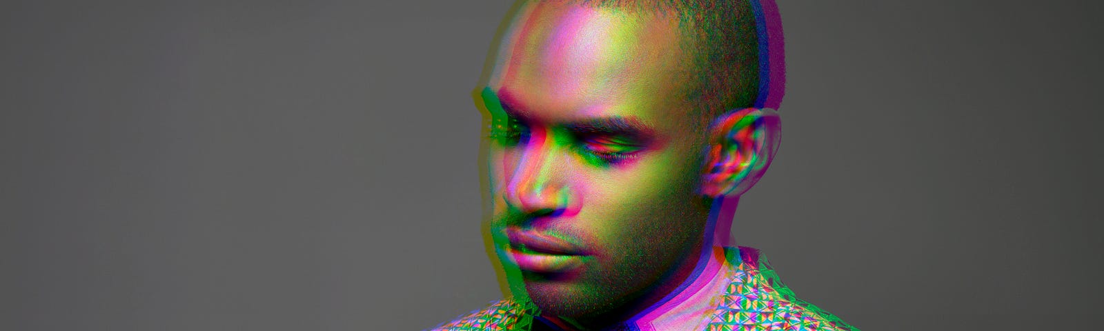 Multiple exposure shot of a Black man wearing a suit looking down.