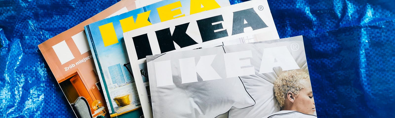 4 Ikea printed catalogues stacked on top of each other against the Ikea FRAKTA blue shopping bag.