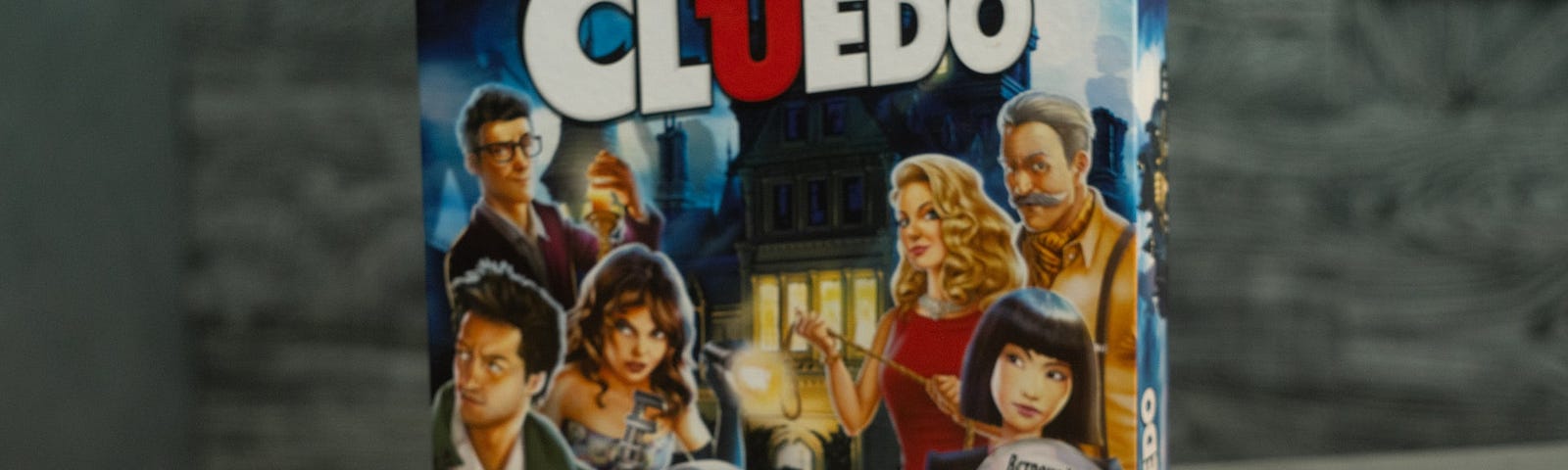 The game of Clue, box, pieces and cards sitting on a table