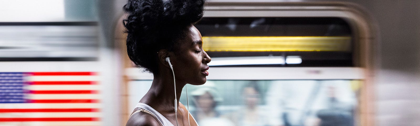 Black woman with eyes closed as subway passes by.