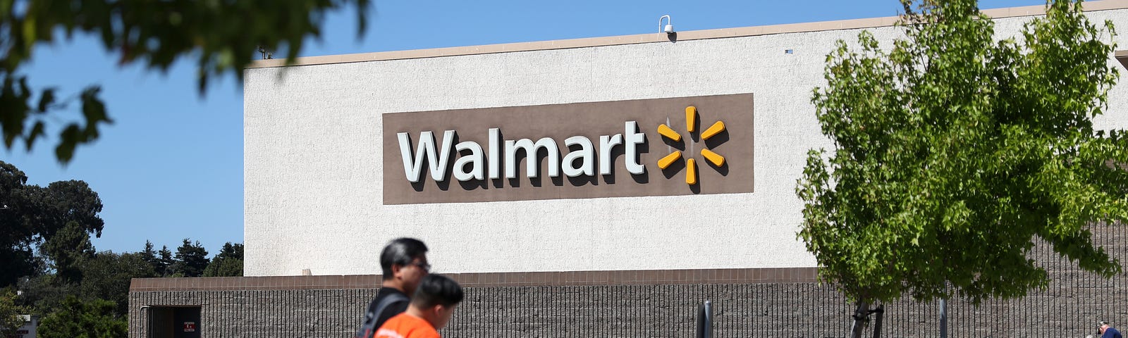 Pedestrians walk by a Walmart store.