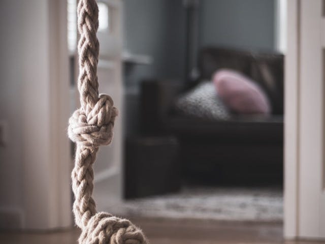 A rope hanging from the ceiling with a sofa in the background