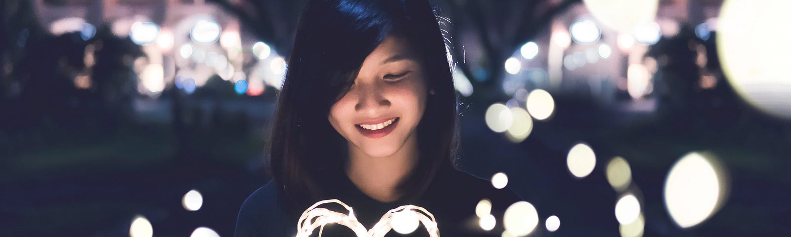 Woman holding a glowing heart.