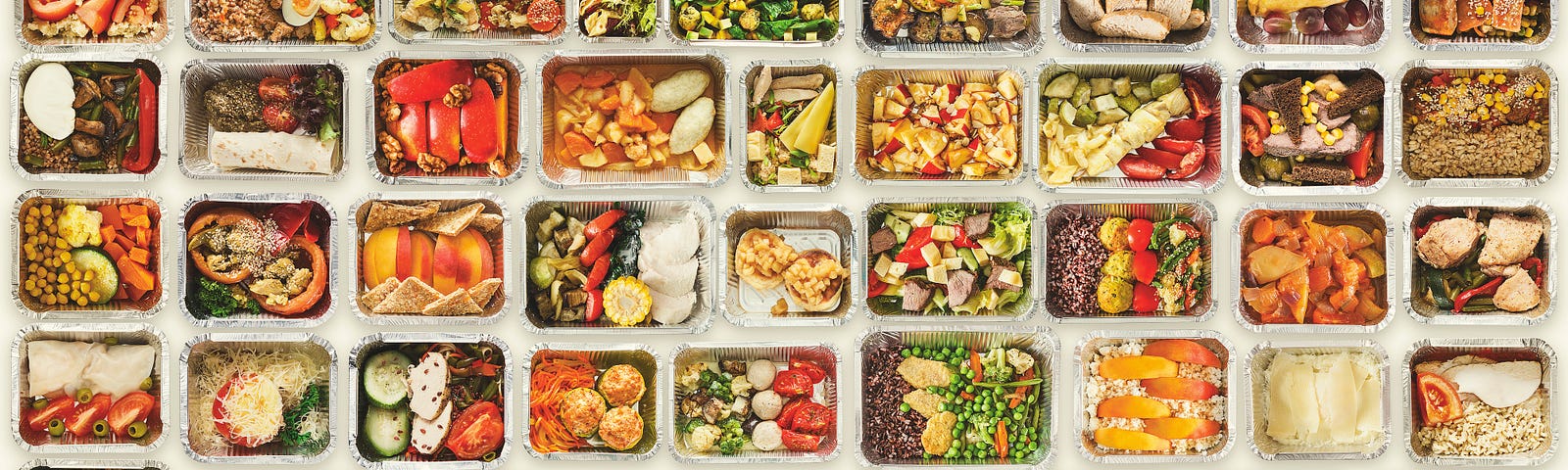 A set of a variety of healthy foods in take away food boxes against a white background.