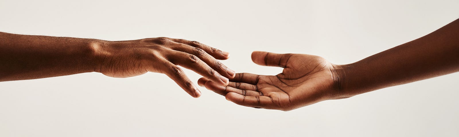 A photo of two hands touching each other.