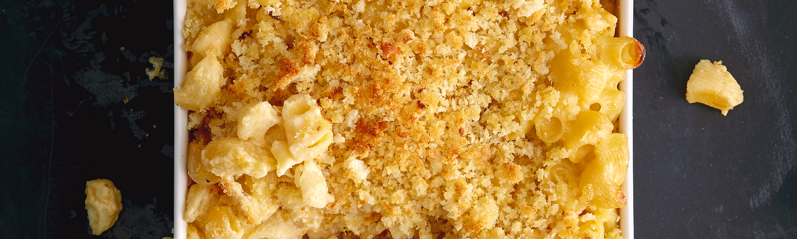 Overhead shot of a casserole dish full of baked macaroni, crispy breadcrumbs on top.