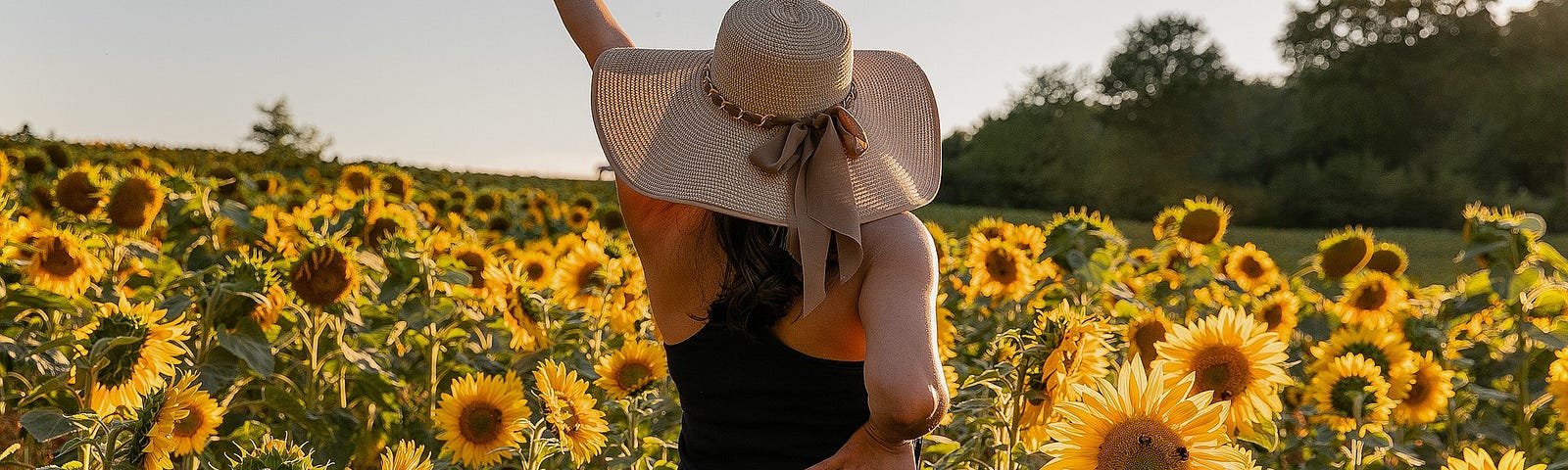 Woman posing joyously in a field of sunflowers