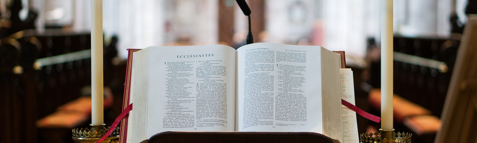 Photo of a Bible open on a pulpit in front of a church.