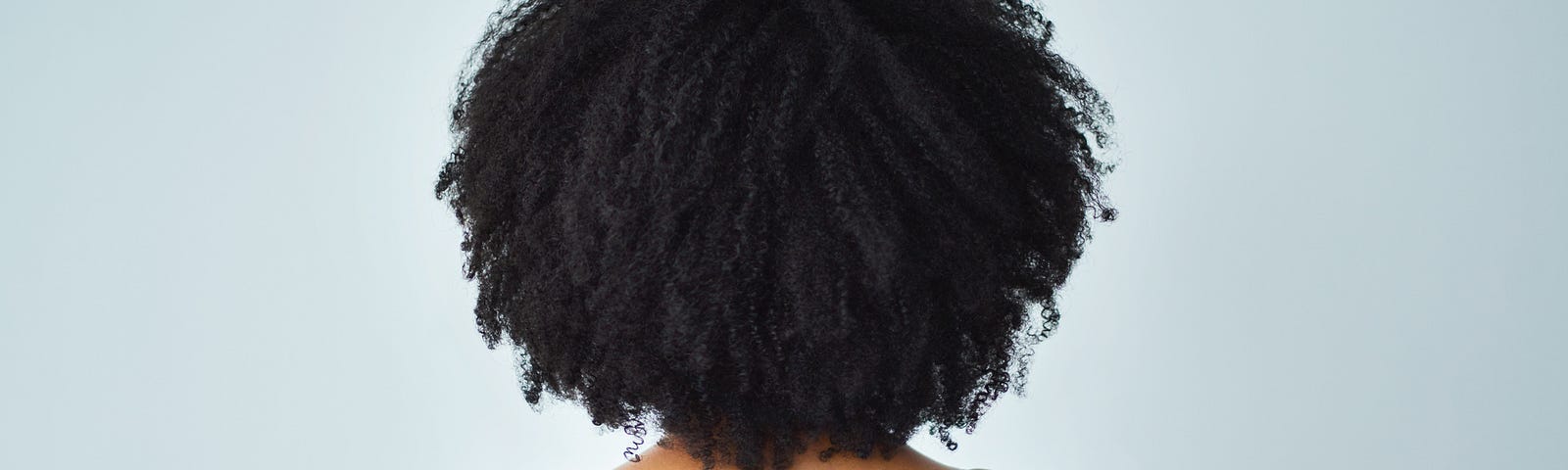 Back view of a Black woman with natural hair.