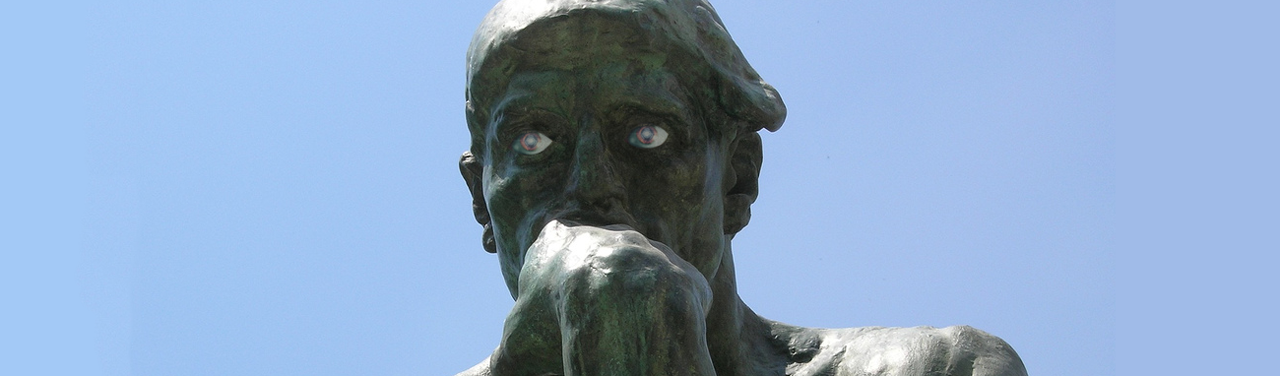 Rodin’s “The Thinker” (a statue with its knuckles against its mouth in thought); lifelike eyeballs have been photoshopped on.