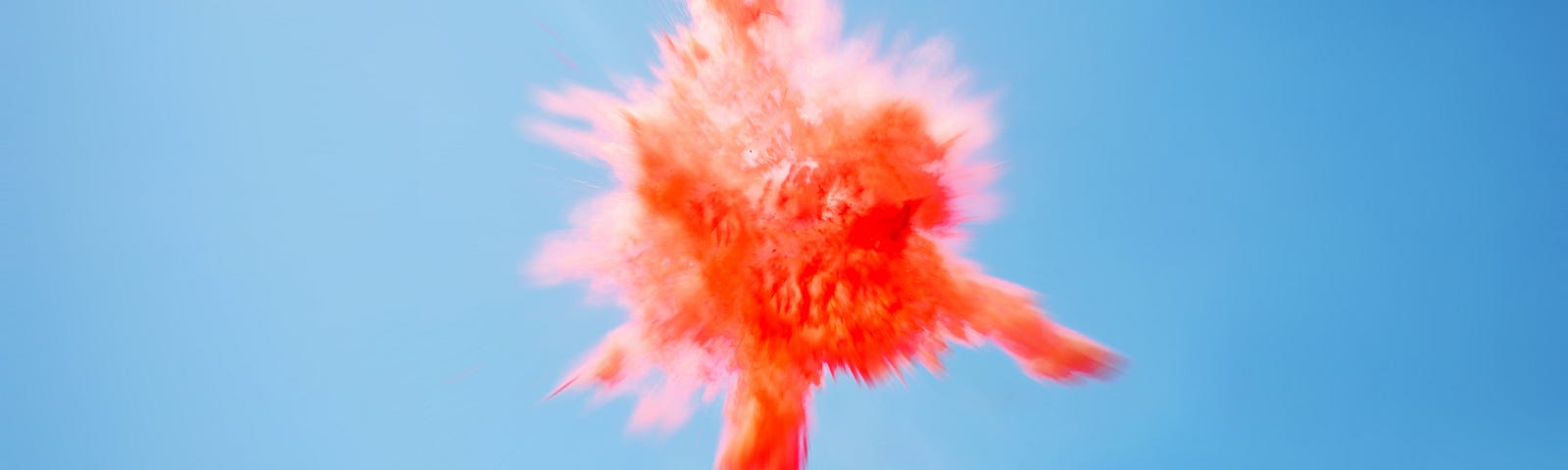 A red powder explosion against a blue background