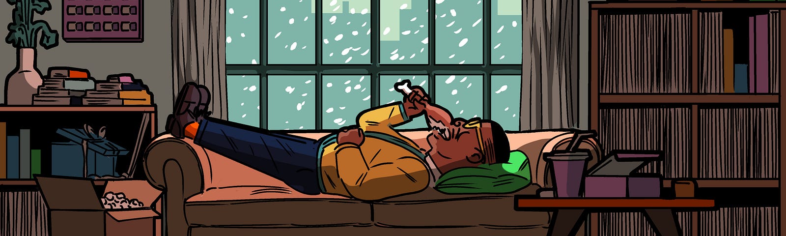 A Black person, lying on a couch in front of a window showing a snowy cityscape, eating a chicken drumstick.