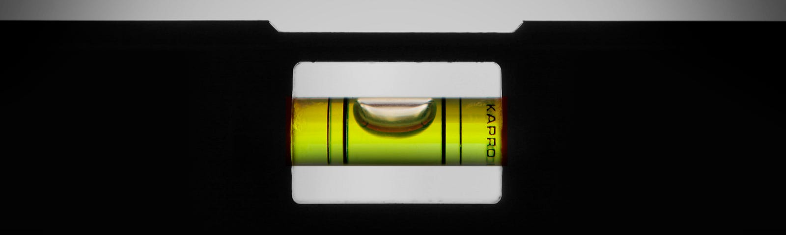 a backlit construction level, showing the bubble carefully centered between the lines