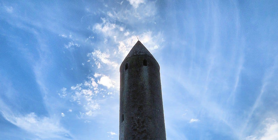 Photograph of a round tower in an Irish graveyard