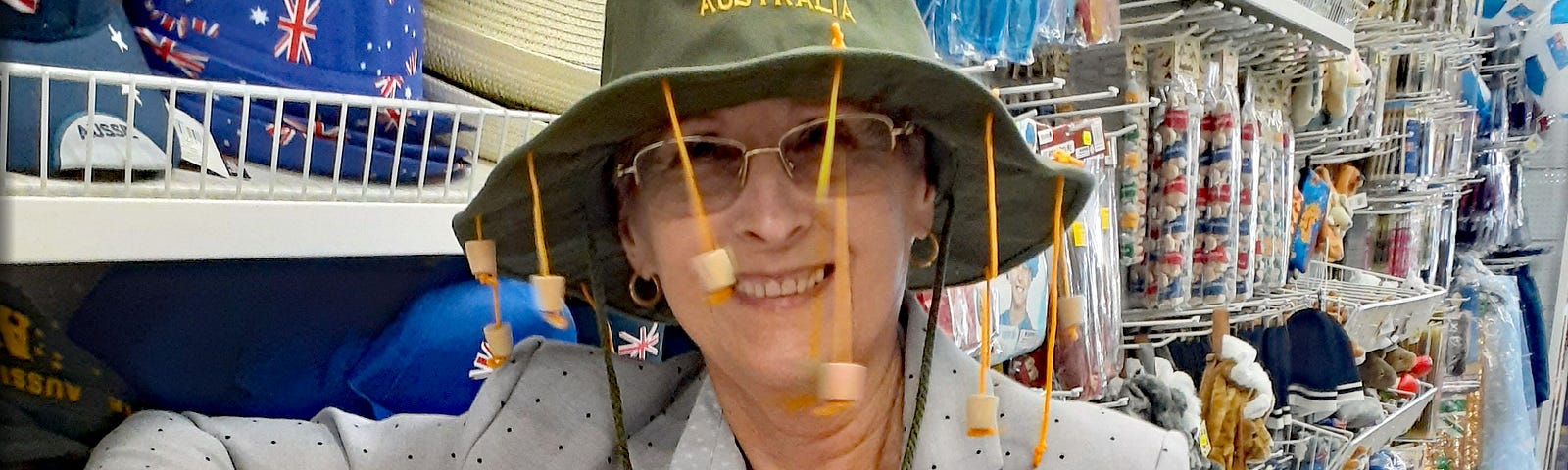 Older Australian woman poses in slouch hat with hanging corks