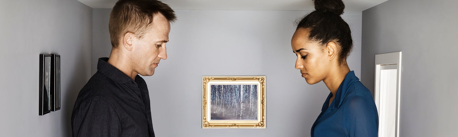 A photo of young couple sitting by the table in small scale dining room, looking unhappy.