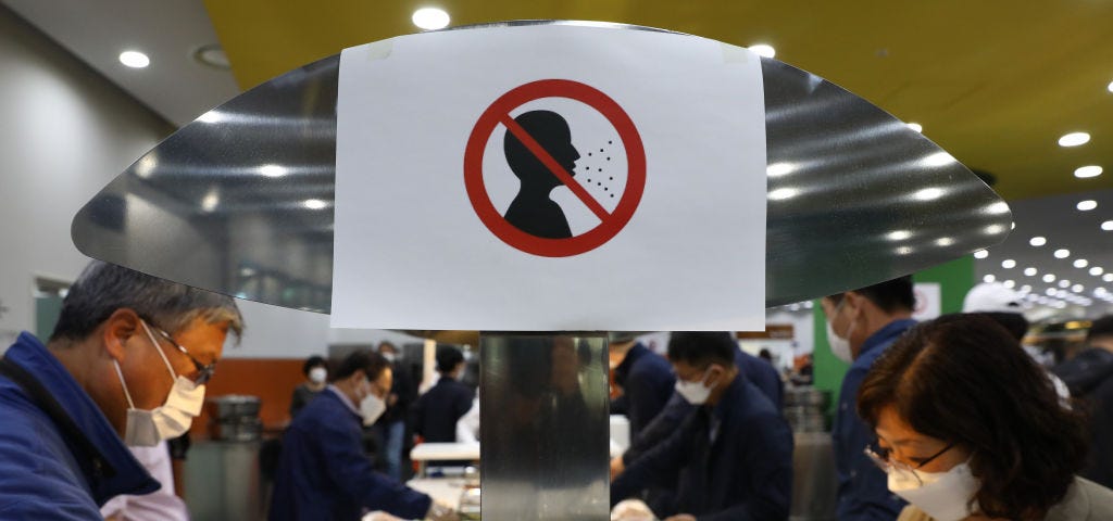 A photo of a sign that prohibits not wearing a face mask at a South Korean cafeteria.