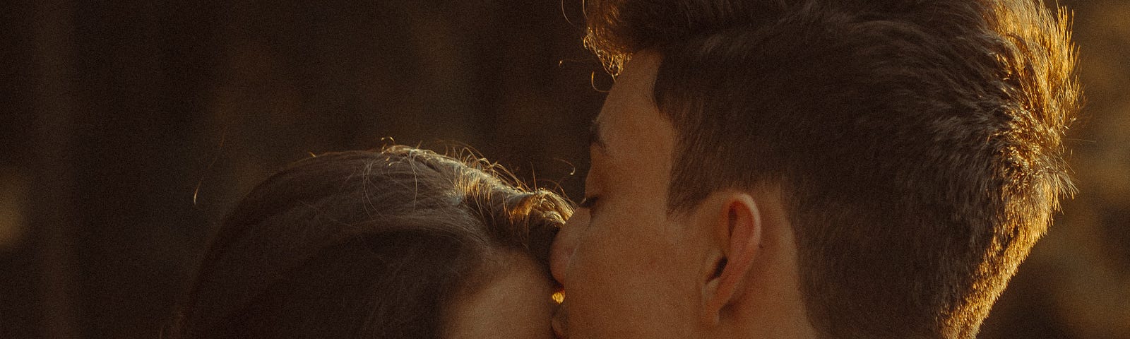 A man kissing a woman’s forehead