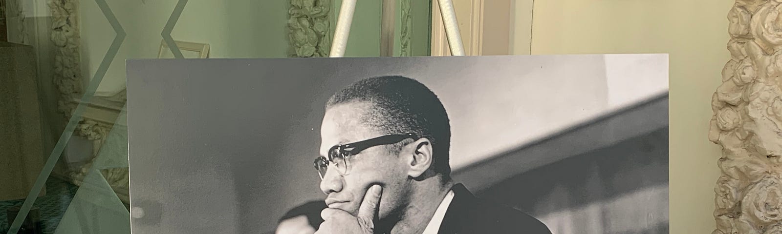 A picture of Malcolm X on an easel.