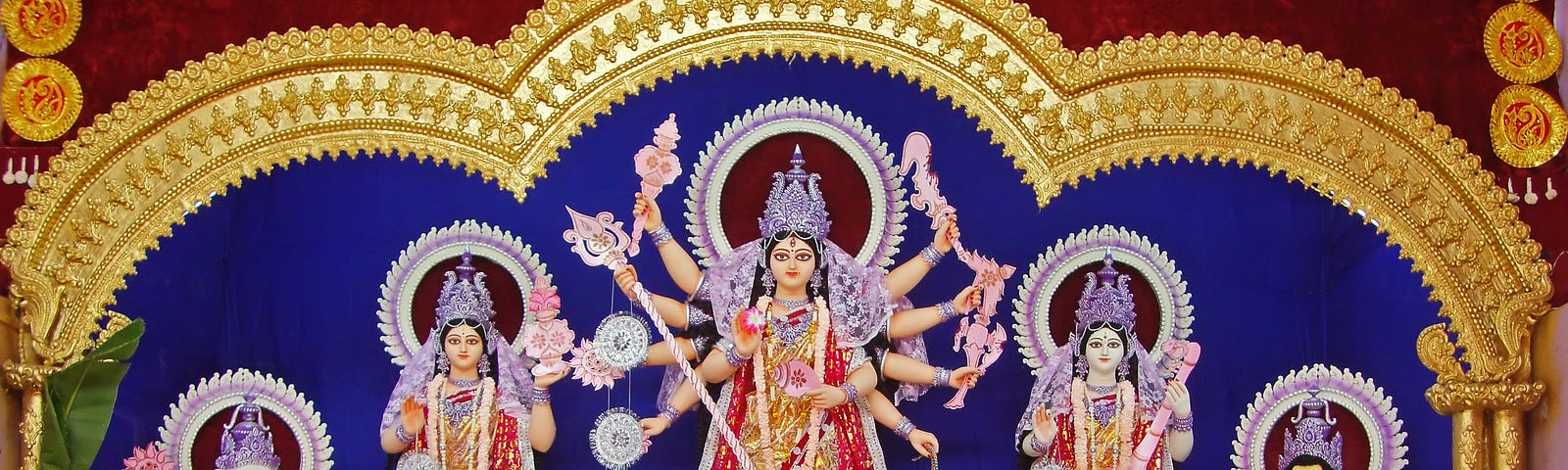 Image of the three forms of Divine Feminine. The center form — Durga — is shown to be killing the demon Mahishasura.