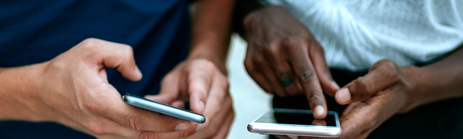 Two people holding their phones.