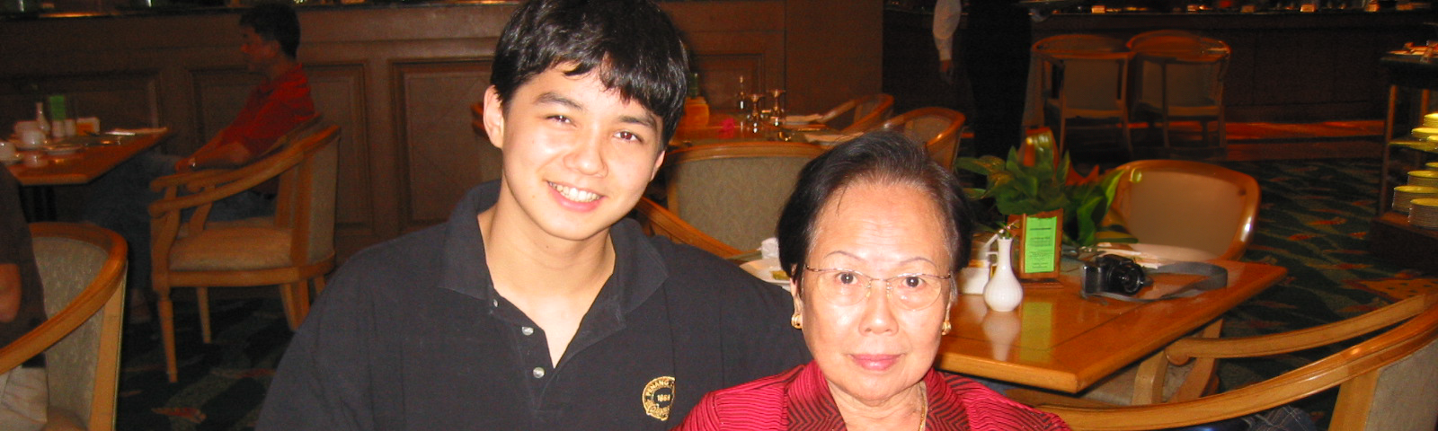 A smiling teenage boy next to his grandma.