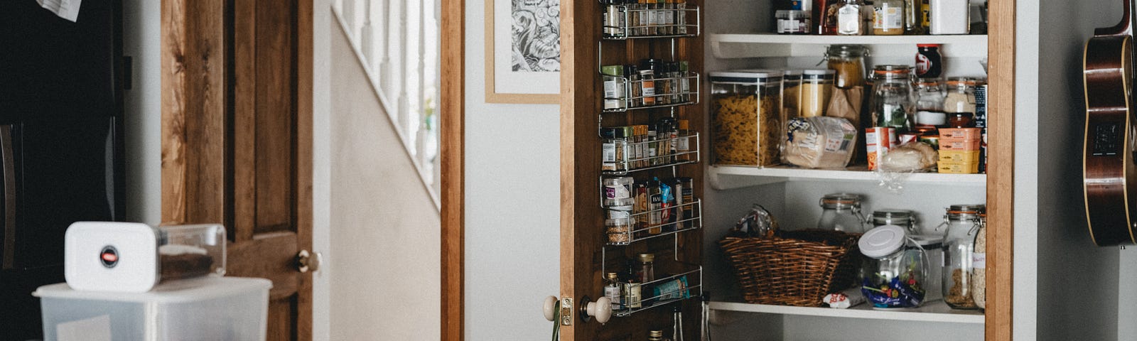 A neat farmhouse kitchen. The well-stocked pantry door is open.