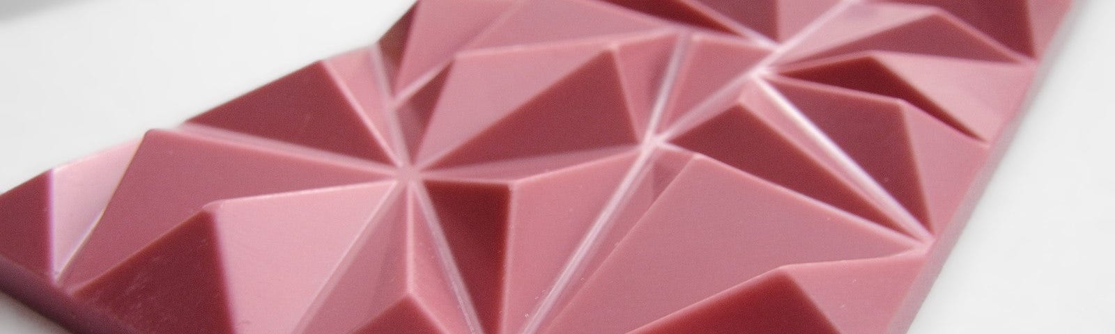 A thin bar of ruby chocolate. Instead of being scored into squares/rectangles, it’s in three-dimensional triangle shapes.