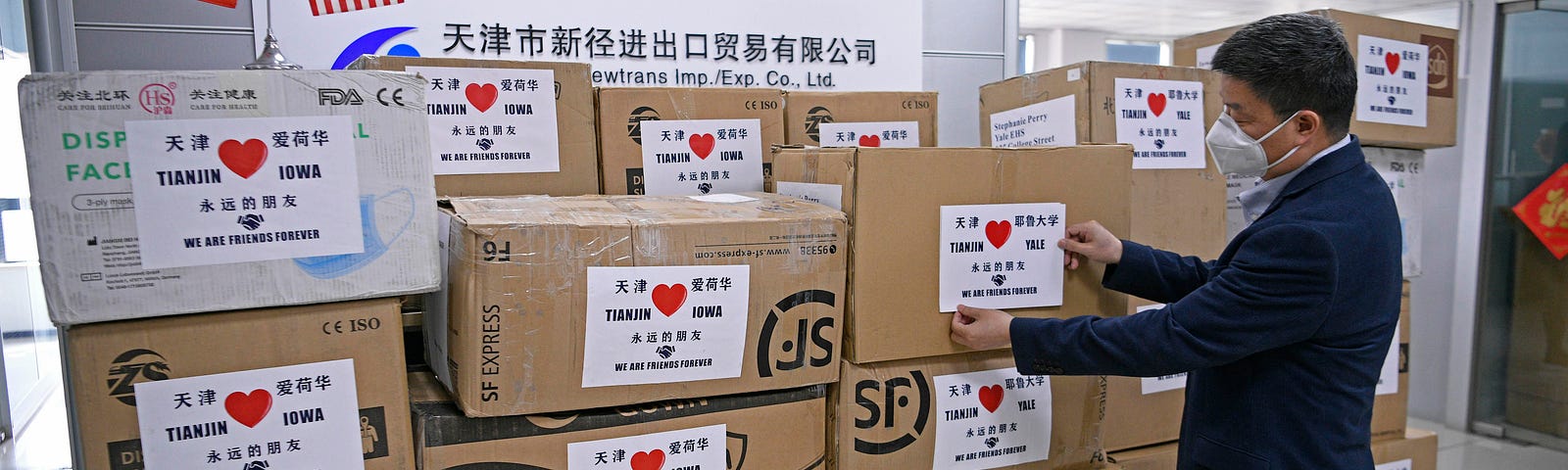 A worker arranges boxes of medical supplies, including 1,000 KN95 masks, 2,000 surgical masks, 100 protective suits and so on