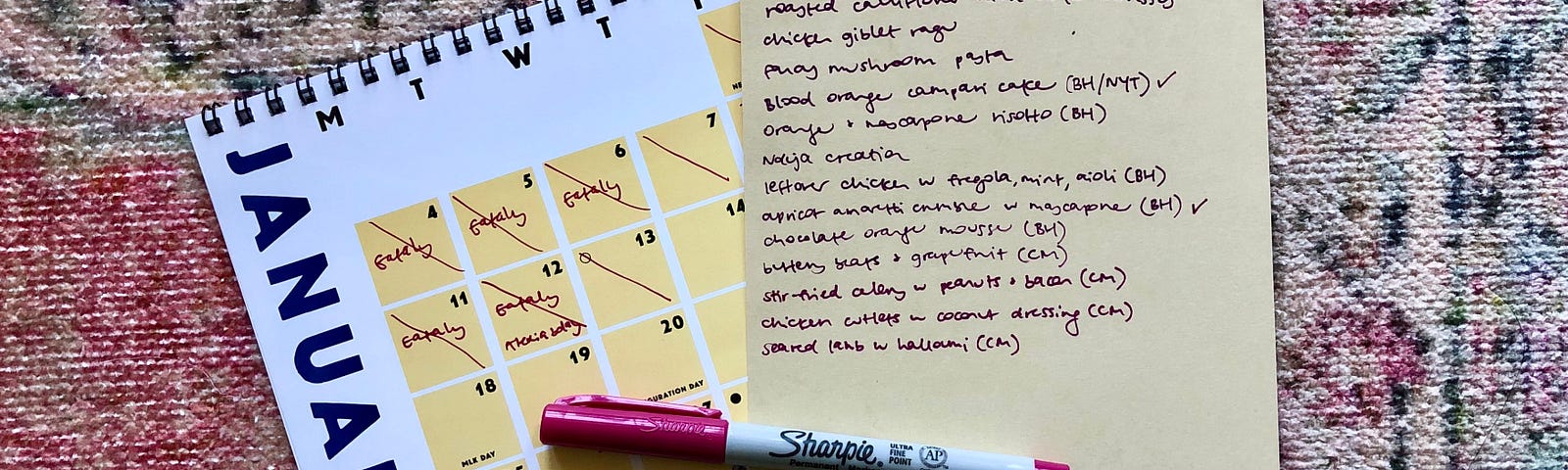 A handwritten list of “Culinary Desires” and a pen on a woven rug next to a calendar turned to the January page.