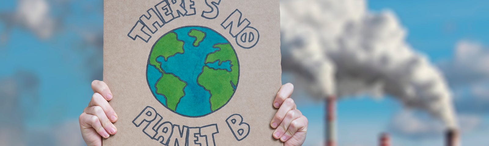 Photo of a hand-lettered cardboard sign reading “There’s no planet B” in the foreground against a three-stack fossil-fuel-burining plant in the background
