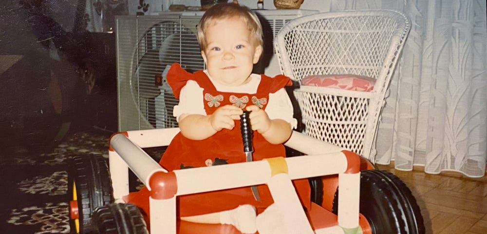 Photo of the author as a baby holding a knife.