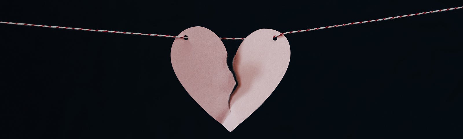 A paper heart hanging on a string is ripped in half. #relationships #breakups #brokenheart #brokenhearted #love