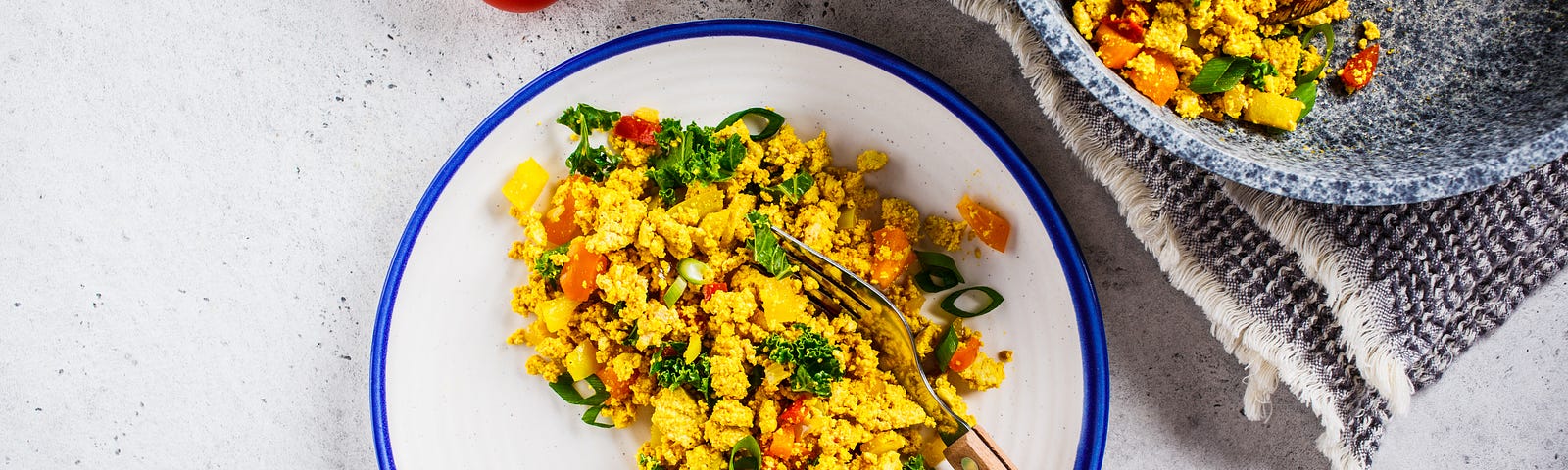 A plate of tofu scramble that’s been dished out of a bigger platter.