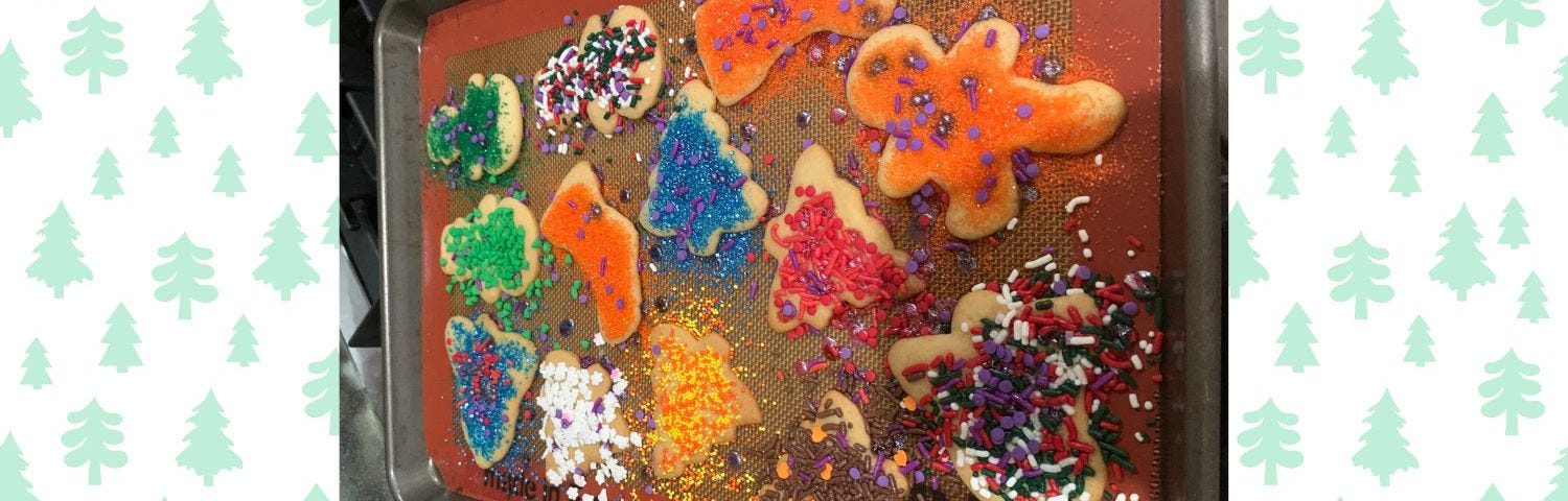 A cookie sheet filled with Christmas sugar cookies.