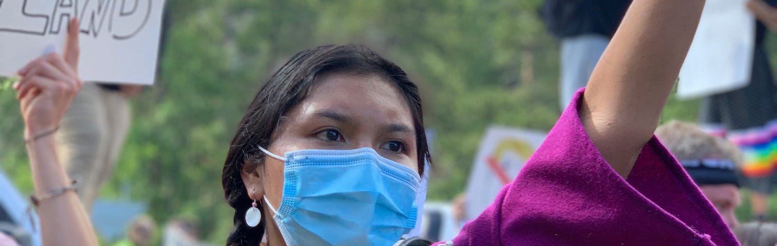 Indigenous woman wearing face mask at a protest in July.