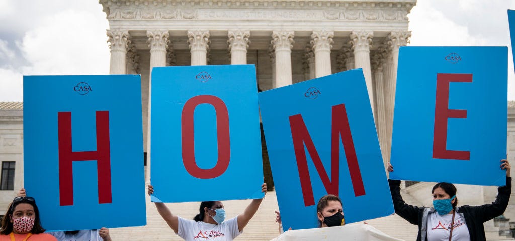 DACA supporters hold up signs that read “HOME” outside the Supreme Court on June 18th, 2020.