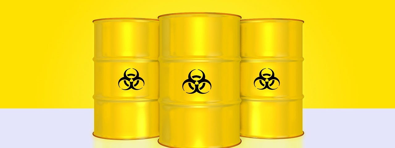 Three bright yellow barrels with toxic waste symbols in black