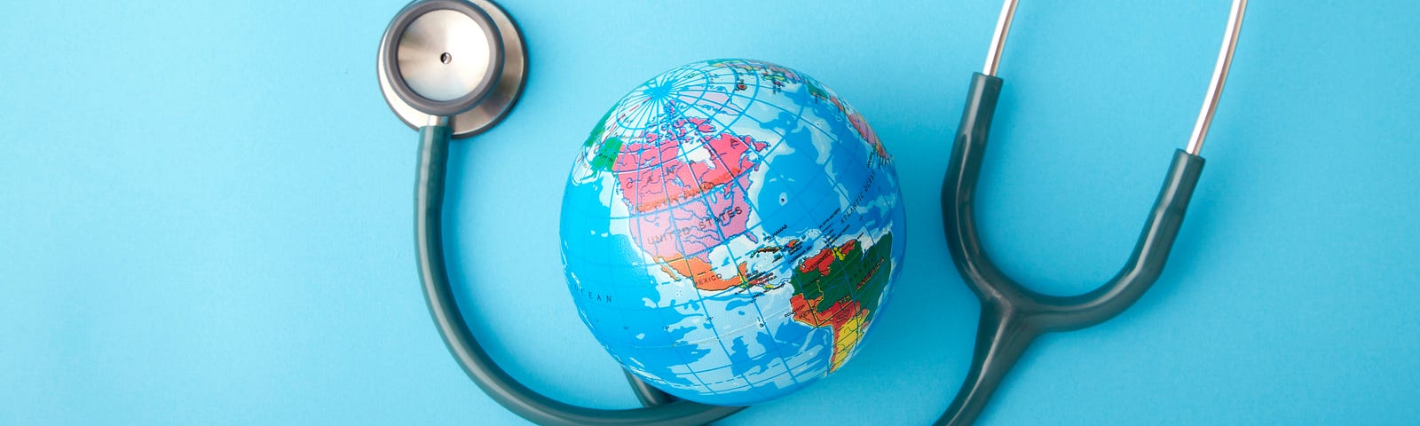 A close up of a stethoscope next to a small globe on a blue background.