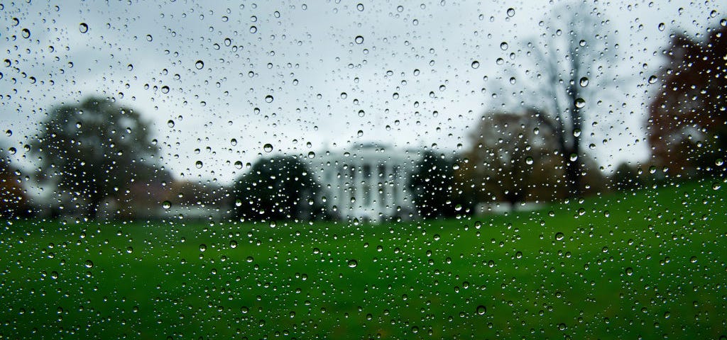 Blurry rain-specked view of the White House on a gloomy day.