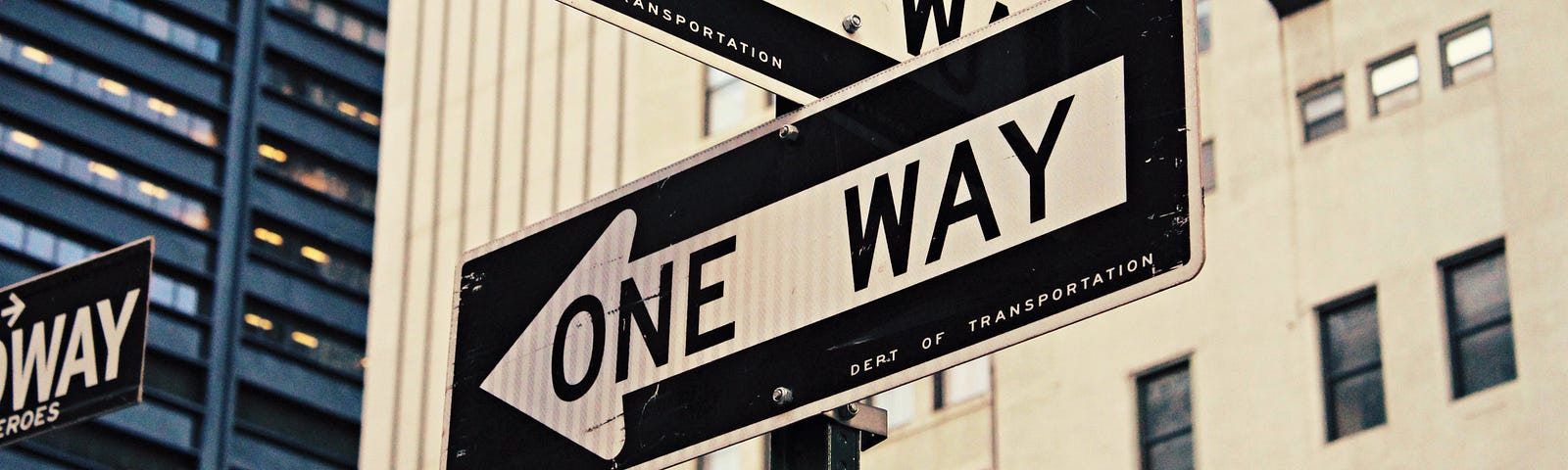 Two one-way signs pointing opposite directions