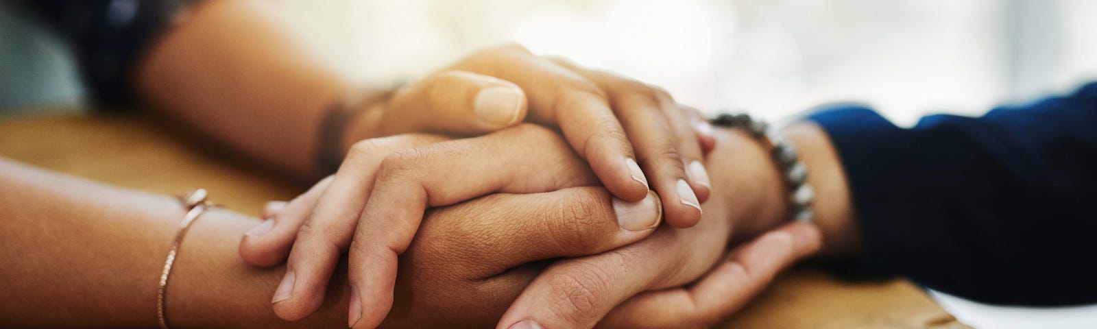 A closeup shot of two unrecognizable people holding hands in comfort