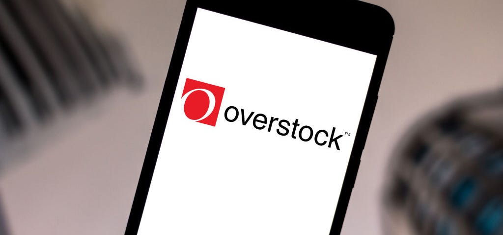 A photo of the Overstock logo on a smartphone.